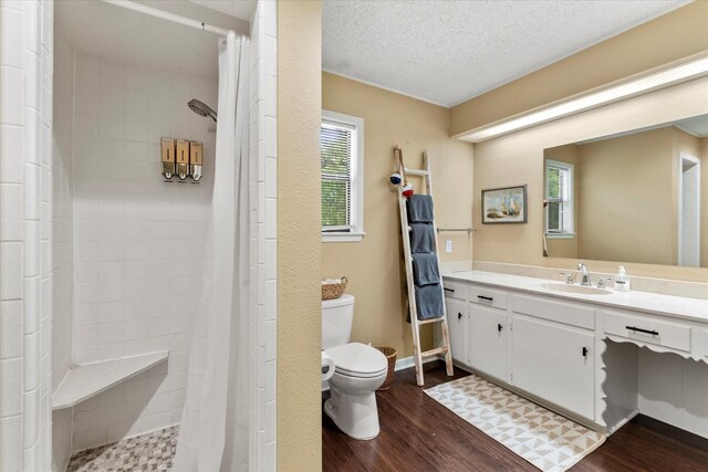 full bath featuring wood finished floors, vanity, toilet, and tiled shower