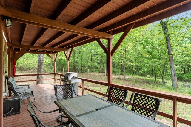 deck featuring a forest view and outdoor dining space