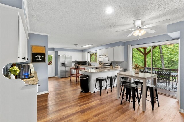 dining space featuring ceiling fan, a textured ceiling, and plenty of natural light