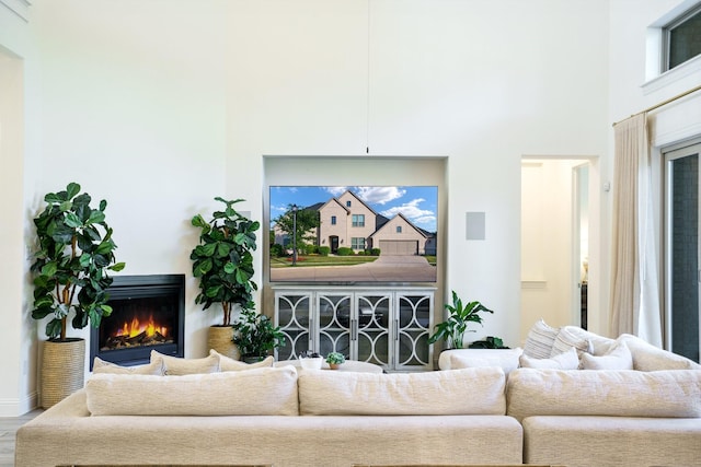 318 Waters Edge Dr, Argyle, TX 76226 - living area with wood finished floors, a towering ceiling, and a lit fireplace