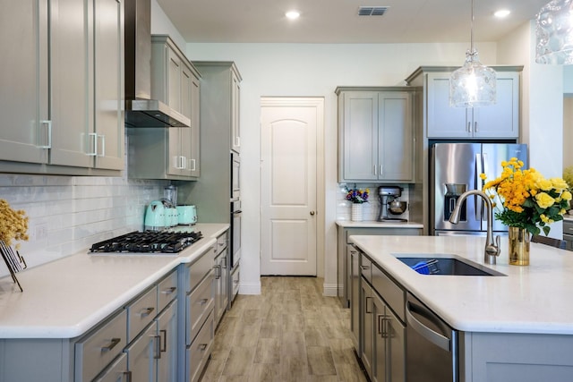 318 Waters Edge Dr, Argyle, TX 76226 - kitchen featuring stainless steel appliances, visible vents, wall chimney range hood, gray cabinets, and a sink