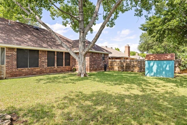view of yard featuring a fenced backyard, an outbuilding, and a shed