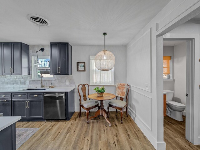 kitchen with light countertops, dishwasher, visible vents, a sink, and light wood-style flooring