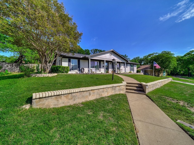 view of front of house with fence, covered porch, and a front yard