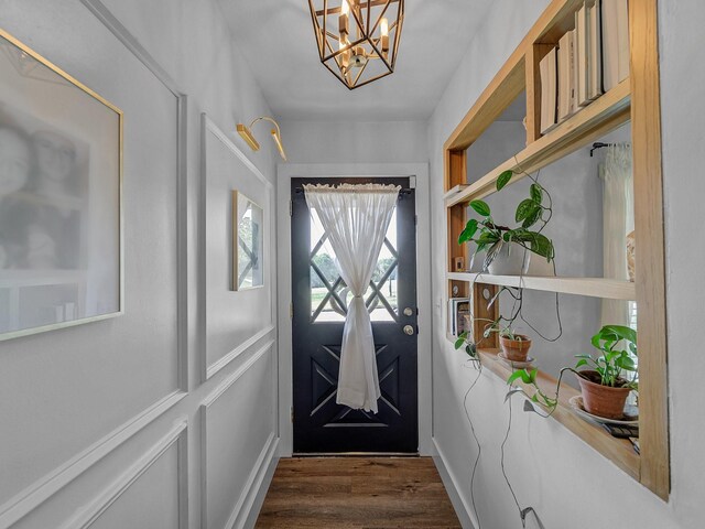 entryway featuring an inviting chandelier and dark wood-style flooring