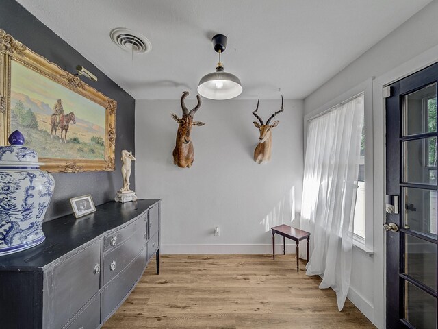 interior space with light wood-style floors, visible vents, and baseboards