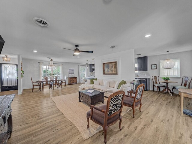 living area featuring recessed lighting, light wood-style floors, and visible vents