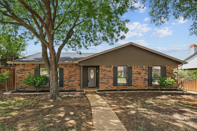 ranch-style house featuring fence and brick siding
