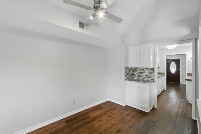 kitchen with ceiling fan, dark wood-style flooring, visible vents, tasteful backsplash, and white cabinetry