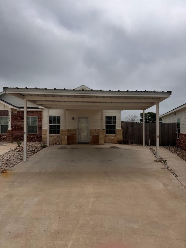 view of front of home with fence and a carport