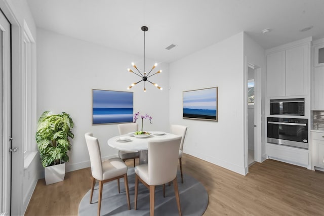 3541 Wardie Pl, Frisco, TX 75033 - dining room with light wood finished floors, baseboards, a chandelier, and visible vents