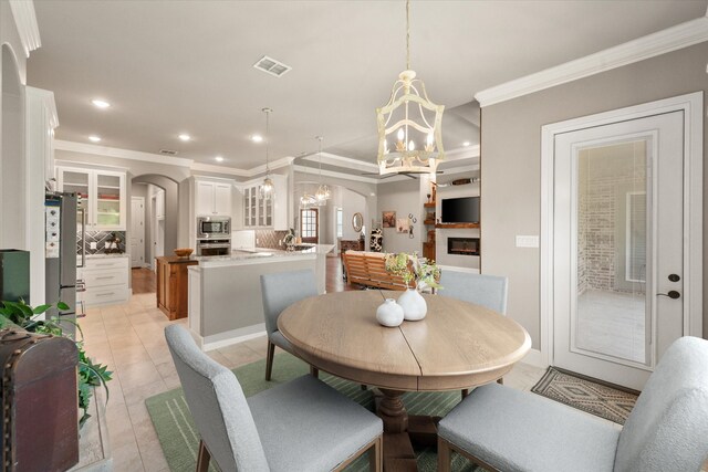 dining area featuring arched walkways, an inviting chandelier, ornamental molding, visible vents, and recessed lighting