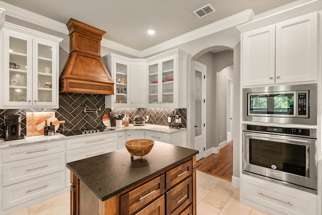 212 Rock Tree Ct, Mansfield, TX 76063 - kitchen with stainless steel appliances, arched walkways, crown molding, white cabinetry, and tasteful backsplash