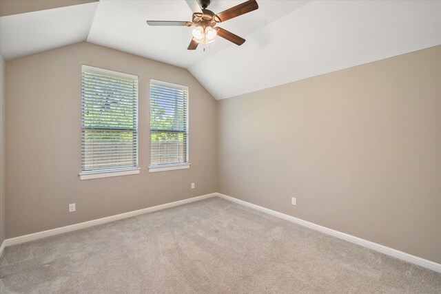interior space with baseboards, lofted ceiling, a ceiling fan, and light colored carpet