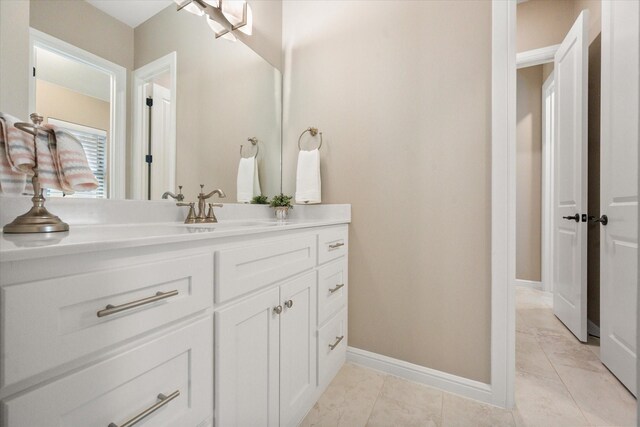 bathroom with baseboards, tile patterned flooring, and vanity