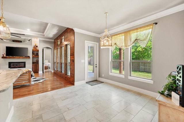 212 Rock Tree Ct, Mansfield, TX 76063 - entryway with crown molding, a chandelier, a ceiling fan, a glass covered fireplace, and baseboards