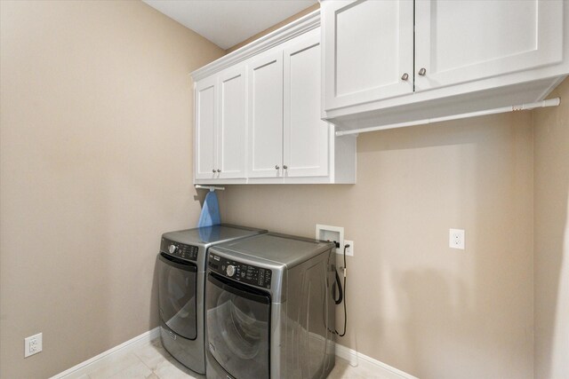 washroom with baseboards, cabinet space, and independent washer and dryer