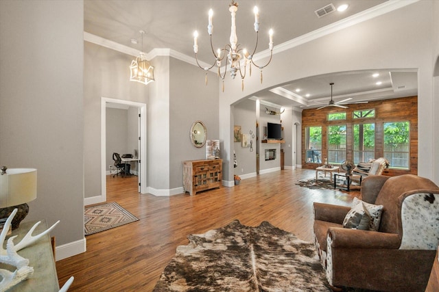 212 Rock Tree Ct, Mansfield, TX 76063 - living room featuring arched walkways, ceiling fan, a chandelier, wood finished floors, and ornamental molding