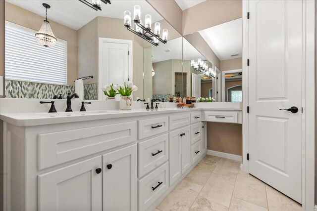 full bathroom featuring a chandelier, tasteful backsplash, double vanity, and a sink