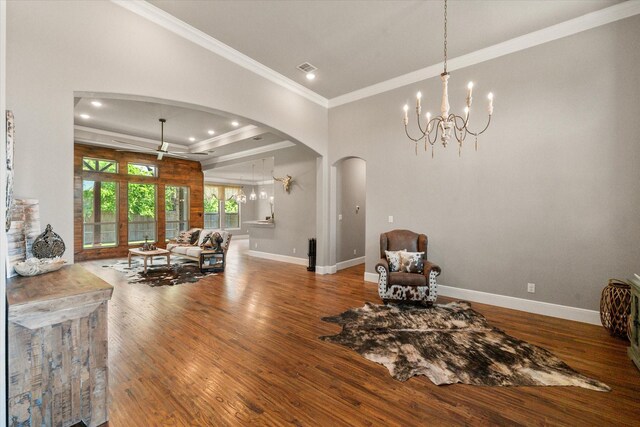 living area featuring an inviting chandelier, wood finished floors, and arched walkways