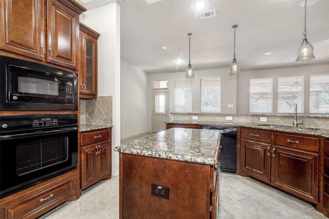 kitchen with a sink, backsplash, black appliances, and a kitchen island