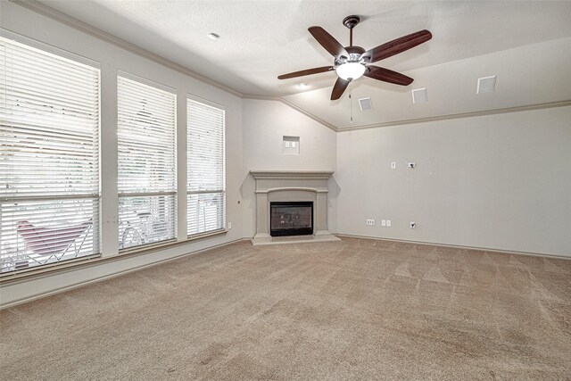 unfurnished living room featuring vaulted ceiling, visible vents, light carpet, crown molding, and ceiling fan