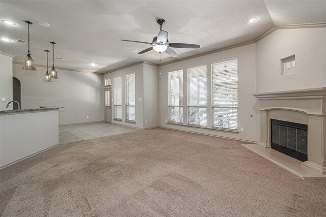 unfurnished living room featuring light carpet, a ceiling fan, a glass covered fireplace, and crown molding