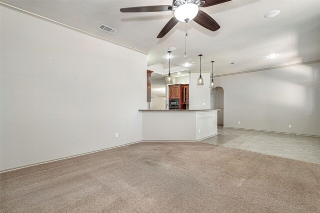 unfurnished living room featuring light colored carpet, ceiling fan, arched walkways, and visible vents