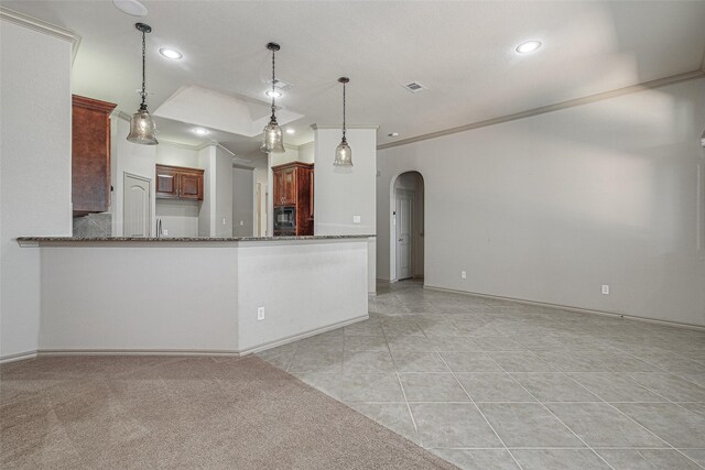 kitchen featuring arched walkways, stone counters, pendant lighting, and recessed lighting