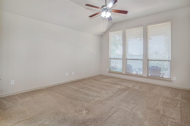 carpeted spare room with vaulted ceiling and ceiling fan