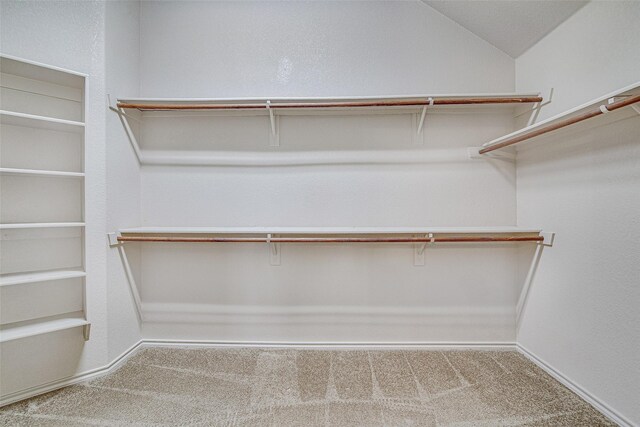 spacious closet featuring lofted ceiling and carpet
