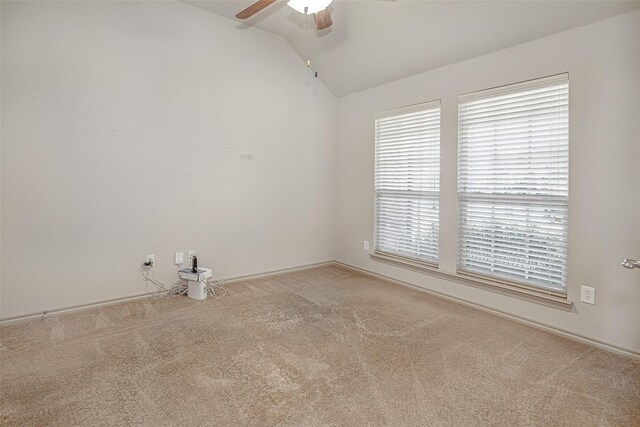 empty room with ceiling fan, vaulted ceiling, and carpet floors