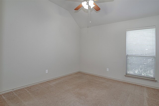 carpeted spare room featuring ceiling fan and lofted ceiling