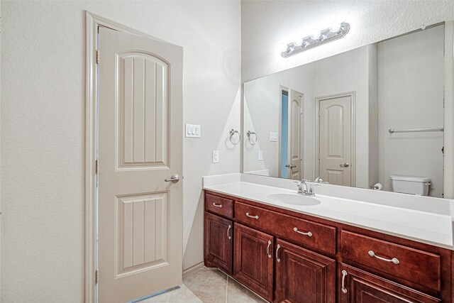 bathroom featuring tile patterned flooring, toilet, and vanity