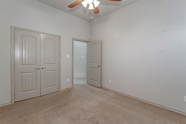 unfurnished bedroom featuring carpet floors, a closet, and a ceiling fan