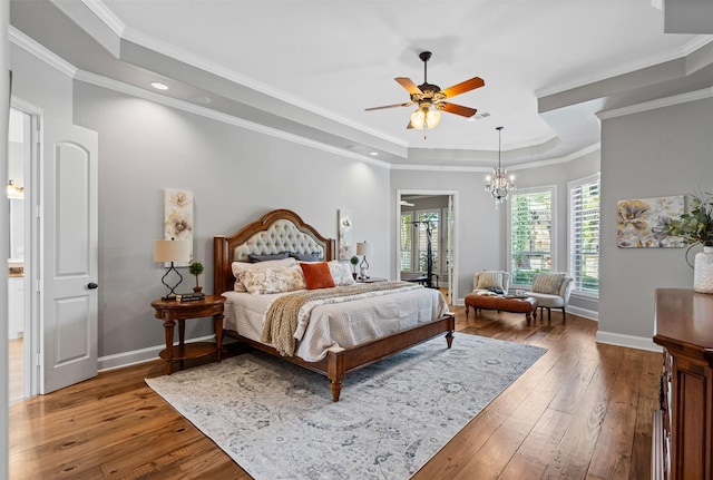 bedroom featuring hardwood / wood-style flooring, baseboards, a tray ceiling, and recessed lighting