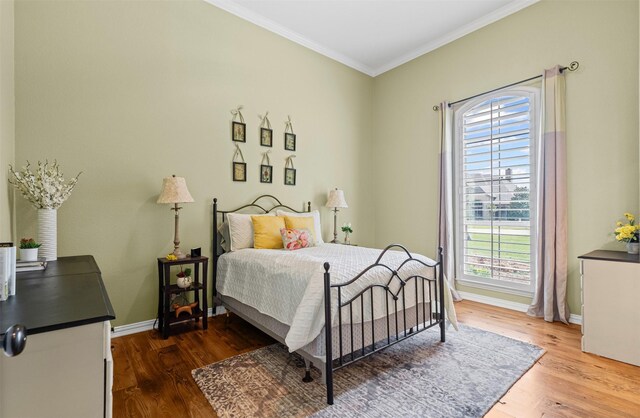 bedroom featuring baseboards, crown molding, dark wood-style floors, and multiple windows
