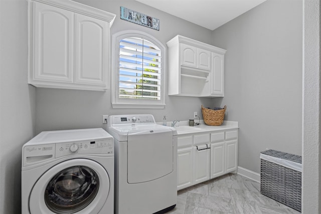 clothes washing area featuring marble finish floor, washer and clothes dryer, a sink, and cabinet space
