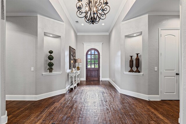 foyer entrance featuring a textured wall, wood finished floors, and a chandelier