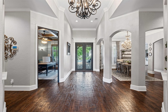 entrance foyer with hardwood / wood-style floors, a textured wall, french doors, and arched walkways
