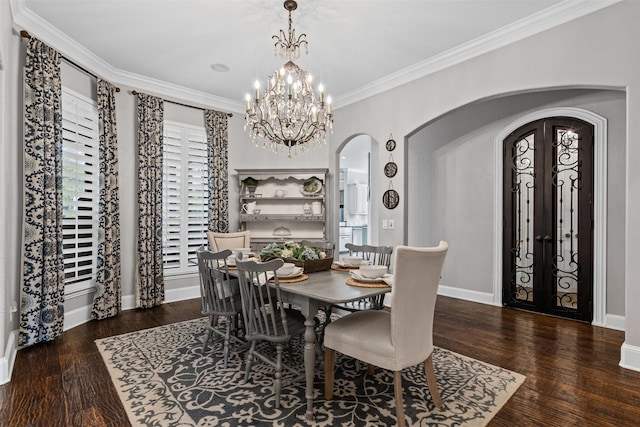 dining space with a notable chandelier, arched walkways, crown molding, and wood finished floors