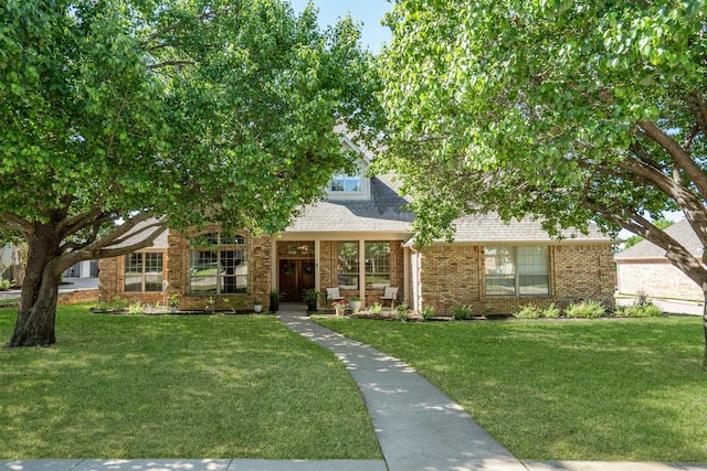 32 Royal Oaks Cir, Denton, TX 76210 - view of property hidden behind natural elements featuring brick siding, a front yard, and a shingled roof