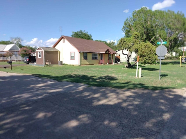view of front of property with a front lawn, a shed, and an outbuilding