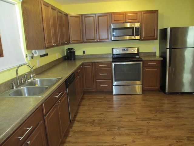kitchen with a sink, stainless steel appliances, and dark wood-type flooring