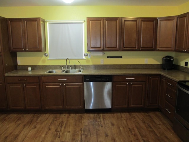 kitchen with dark brown cabinetry, a sink, appliances with stainless steel finishes, and dark wood-style flooring