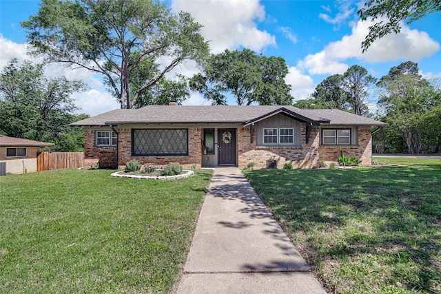 ranch-style house featuring a front lawn, brick siding, and fence