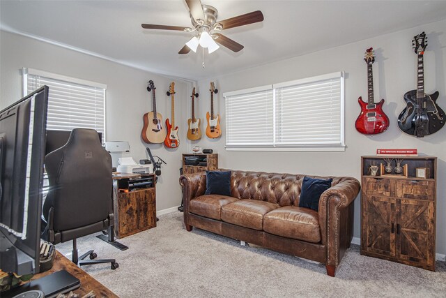 carpeted office with baseboards and a ceiling fan