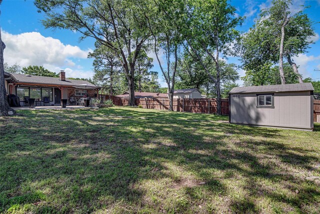 view of yard with an outdoor structure, a patio area, and a fenced backyard
