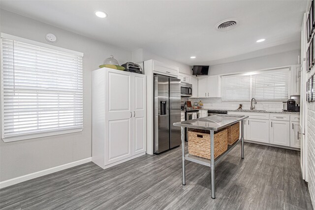 kitchen featuring white cabinets, appliances with stainless steel finishes, a sink, and visible vents