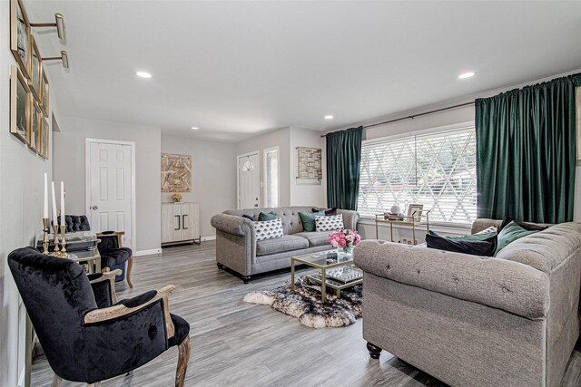 living room featuring baseboards, wood finished floors, and recessed lighting